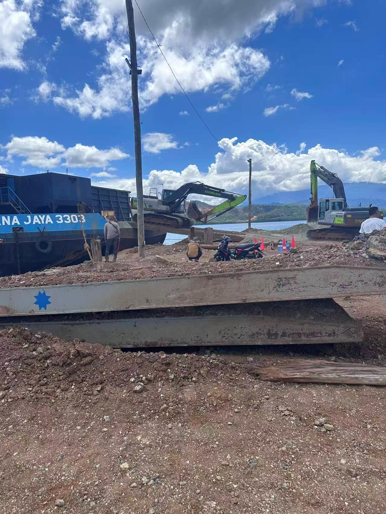 Aktivitas pekerja dan alat berat di area dermaga pemuatan